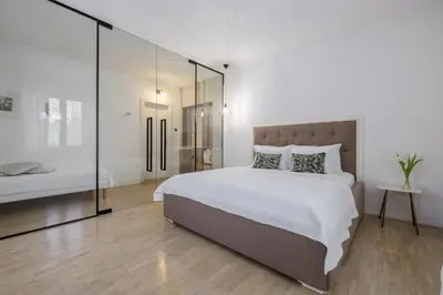a bedroom with a large bed and a glass wall at City Central in Ljubljana