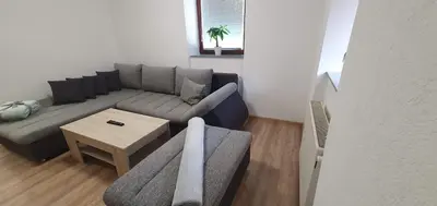 a living room with a couch and a table at Apartment Podkuze in Mojstrana