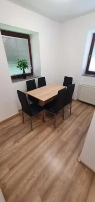 a dining room with a wooden table and chairs at Apartment Podkuze in Mojstrana
