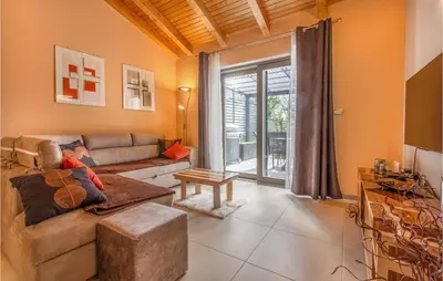 a living room with a couch and a table at 3 Bedroom Awesome Home In Divaca in Divača