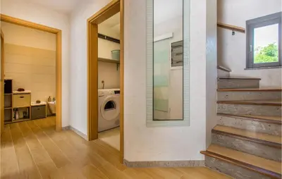 a laundry room with a washing machine and a staircase at 3 Bedroom Awesome Home In Divaca in Divača