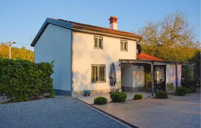 a white house with a patio in front of it at 3 Bedroom Awesome Home In Divaca in Divača