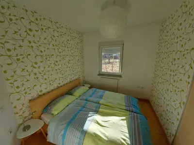 a small bedroom with a bed and a window at APARTMA GONZO in Bovec