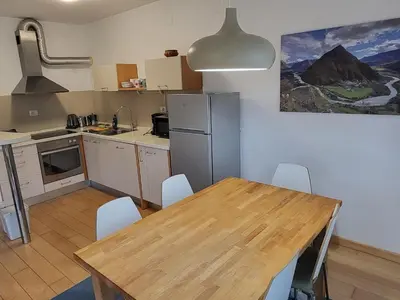 a kitchen with a wooden table and a refrigerator at APARTMA GONZO in Bovec