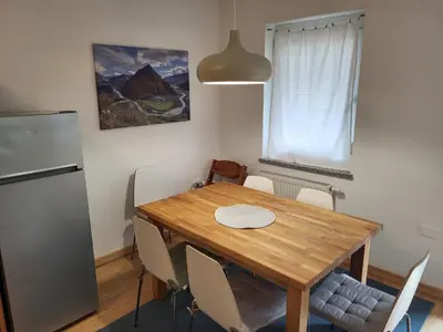 a dining room table with chairs and a refrigerator at APARTMA GONZO in Bovec