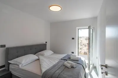 a white bedroom with a bed with towels on it at Villa Rosemary Trieste HerMes arT in Sežana