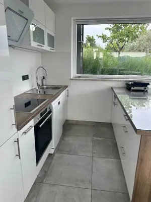 a white kitchen with a sink and a window at Villa Rosemary Trieste HerMes arT in Sežana