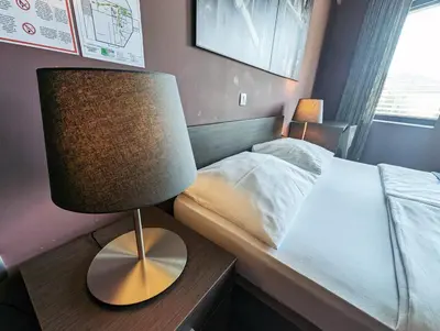 a bedroom with a bed and a lamp on a table at Nitro Rooms in Ljubljana