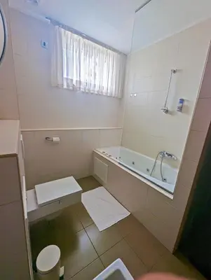 a bathroom with a tub and a toilet and a sink at Nitro Rooms in Ljubljana