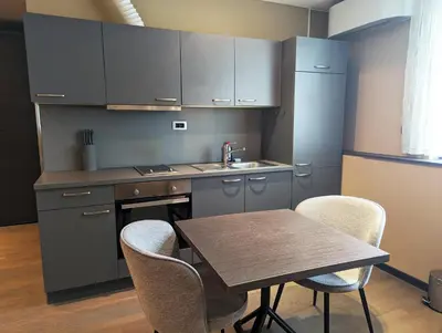 a kitchen with a table and chairs and a sink at Nitro Rooms in Ljubljana
