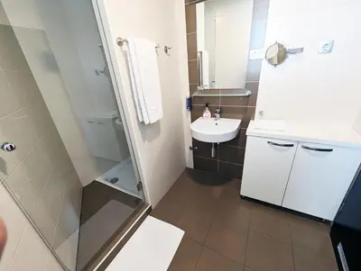 a small bathroom with a sink and a shower at Nitro Rooms in Ljubljana