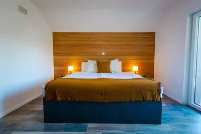 a bedroom with a large bed with a wooden headboard at Holiday home in Smarjeske Toplice Kranjska Krain 42904 in Smarjeske Toplice