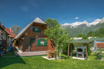 a log cabin with mountains in the background at Počitniška hiška Jrga in Bovec