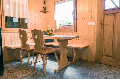 a wooden table and two chairs in a room at Počitniška hiška Jrga in Bovec