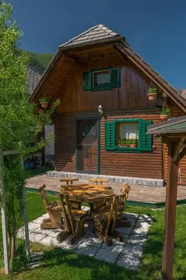 a wooden cabin with a picnic table in front of it at Počitniška hiška Jrga in Bovec