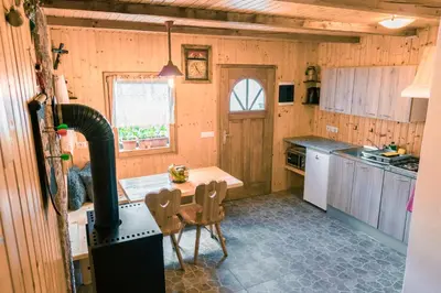 a kitchen with a stove and a table in it at Počitniška hiška Jrga in Bovec