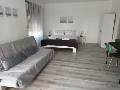 a living room with a couch and a bed at Apartma ODDIH in Dutovlje