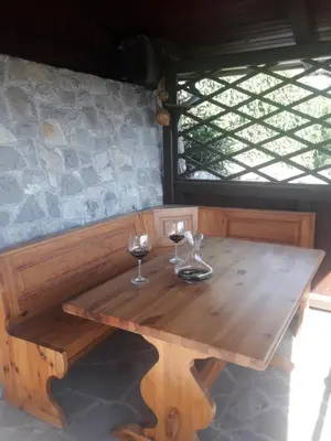 a wooden table with two glasses of wine on it at Apartma ODDIH in Dutovlje