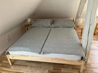 a bed with a wooden frame in a room at Apartment Malina - free private parking in Ljubljana