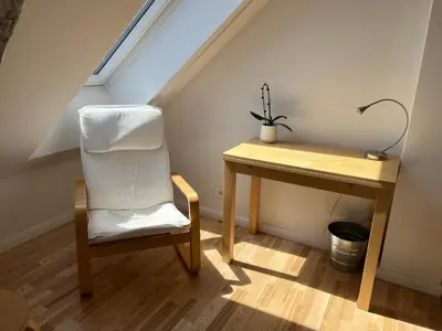 a white chair sitting next to a desk in a attic at Apartment Malina - free private parking in Ljubljana