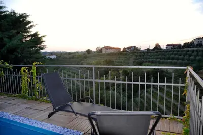 a chair sitting on a deck next to a fence at Apartment in the heart of Brda wine region, Darinka Marinič in Dobrovo