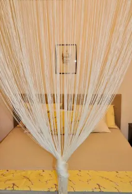 a bed with white curtains on top of it at Apartment in the heart of Brda wine region, Darinka Marinič in Dobrovo