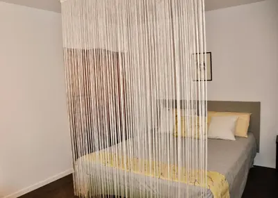 a bedroom with a bed with a curtain over it at Apartment in the heart of Brda wine region, Darinka Marinič in Dobrovo
