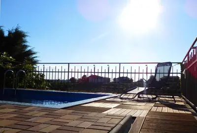 a swimming pool next to a fence with the ocean in the background at Apartment in the heart of Brda wine region, Darinka Marinič in Dobrovo
