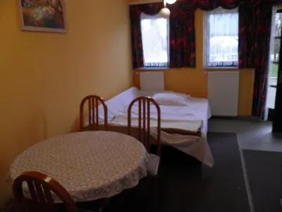 a room with two beds and a table and chairs at Pri štorklji in Moravske Toplice