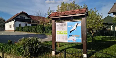 a sign in the grass in front of a house at Pri štorklji in Moravske Toplice
