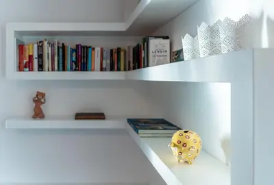 a white book shelf with books on it at Apartment Panoramic Bovec in Bovec