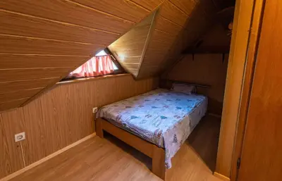 a small bed in a wooden room with a window at Holiday home in Novo Mesto - Dolenjska Bela krajina Unter- Weißkrain 42895 in Novo Mesto