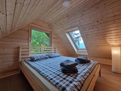 a bedroom with a bed in a wooden cabin at Počitniška hiša Mlekarna Grant in Grahovo