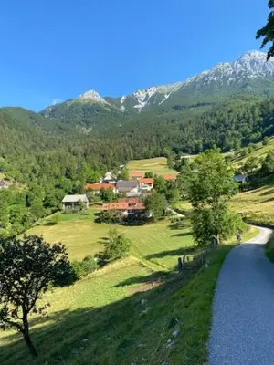 a house on a hill next to a body of water at Počitniška hiša Mlekarna Grant in Grahovo