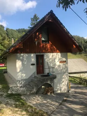 a small house with a fireplace in front of it at Počitniška hiša Mlekarna Grant in Grahovo