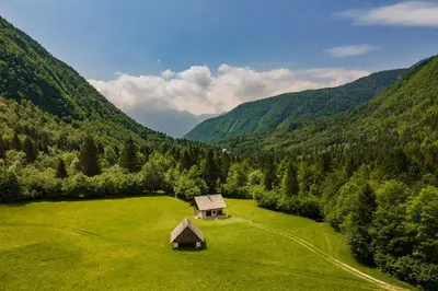 a small cabin in a field in the mountains at Počitniška Hiša Voje in Srednja Vas v Bohinju
