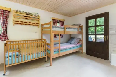 a room with two bunk beds and a door at Počitniška Hiša Voje in Srednja Vas v Bohinju