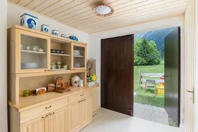 a kitchen with wooden cabinets and a sliding door at Počitniška Hiša Voje in Srednja Vas v Bohinju