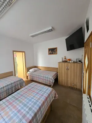 a hotel room with two beds and a flat screen tv at Guest house Kočanija in Ilirska Bistrica