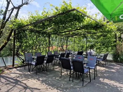 a group of tables and chairs under a pergola at Guest house Kočanija in Ilirska Bistrica