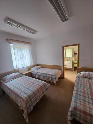 a room with two beds and a mirror at Guest house Kočanija in Ilirska Bistrica