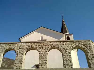 a church with a steeple on top of a brick building at Studio Brnat in Kobarid