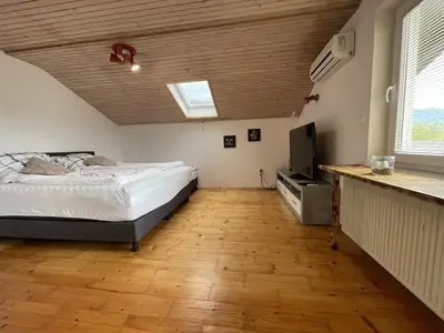 a bedroom with a bed and a flat screen tv at Apartment LakeBled with Casle Bled view in Bled