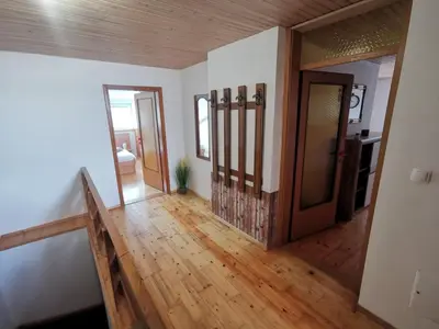 a hallway with a wooden door and wooden floors at Apartment LakeBled with Casle Bled view in Bled