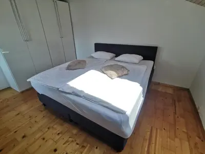 a bedroom with a bed with white sheets and pillows at Apartment LakeBled with Casle Bled view in Bled