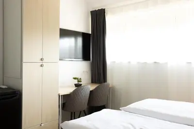 a bedroom with a desk and a bed and a table at Apartments Trzin-Mlake w FREE Parking in Trzin
