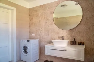 a bathroom with a sink and a washing machine at Holiday Home Lož in Stari Trg pri Ložu