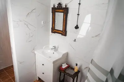 a white bathroom with a sink and a mirror at Country House Sveta Ana in Stari Trg pri Ložu