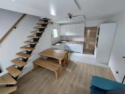 a room with a staircase and a table and a kitchen at River Apartment in Bovec