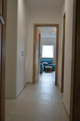 a hallway with a room with a couch and a door at River Apartment in Bovec